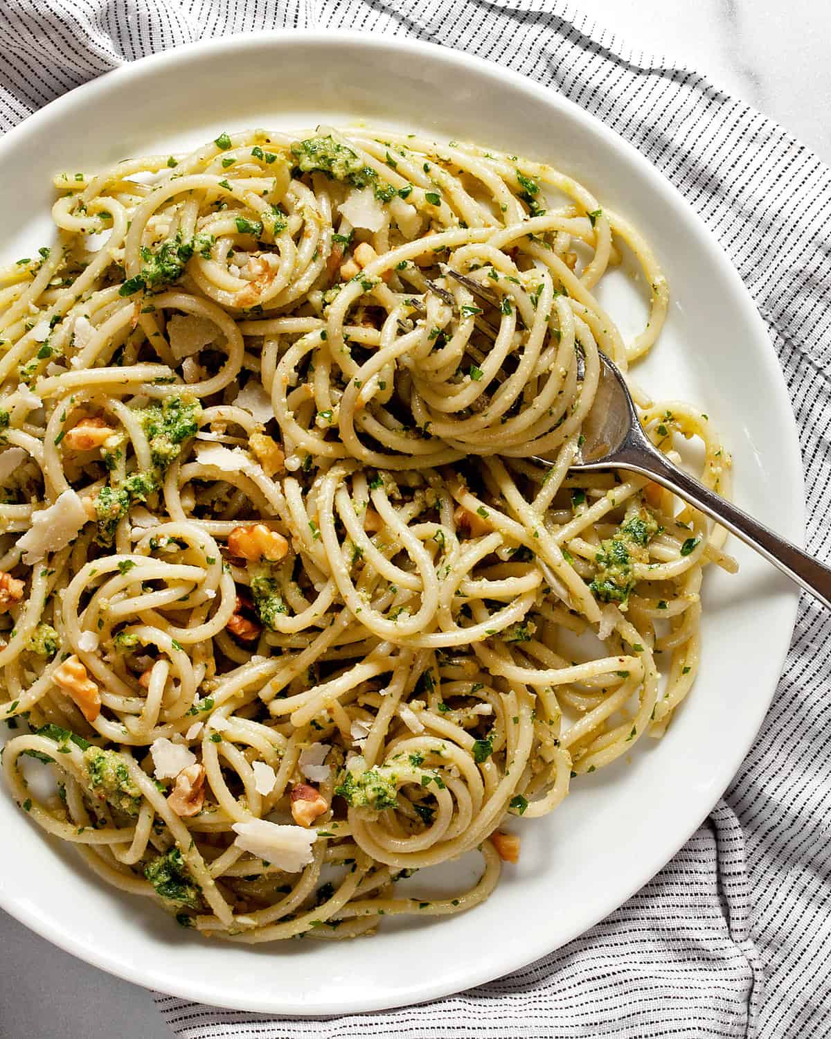 For tisted in spaghetti with parsley pesto on a plate.