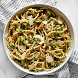 Spaghetti in a bowl tossed with parsley pesto.
