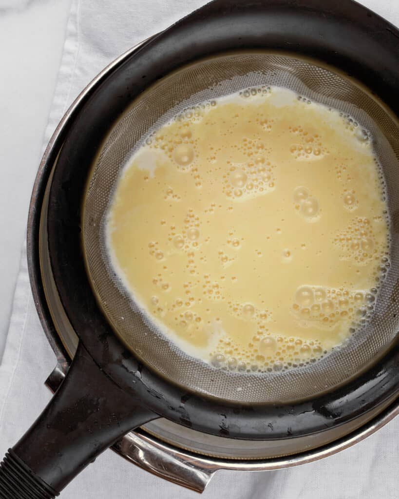 Straining custard for ice cream into bowl