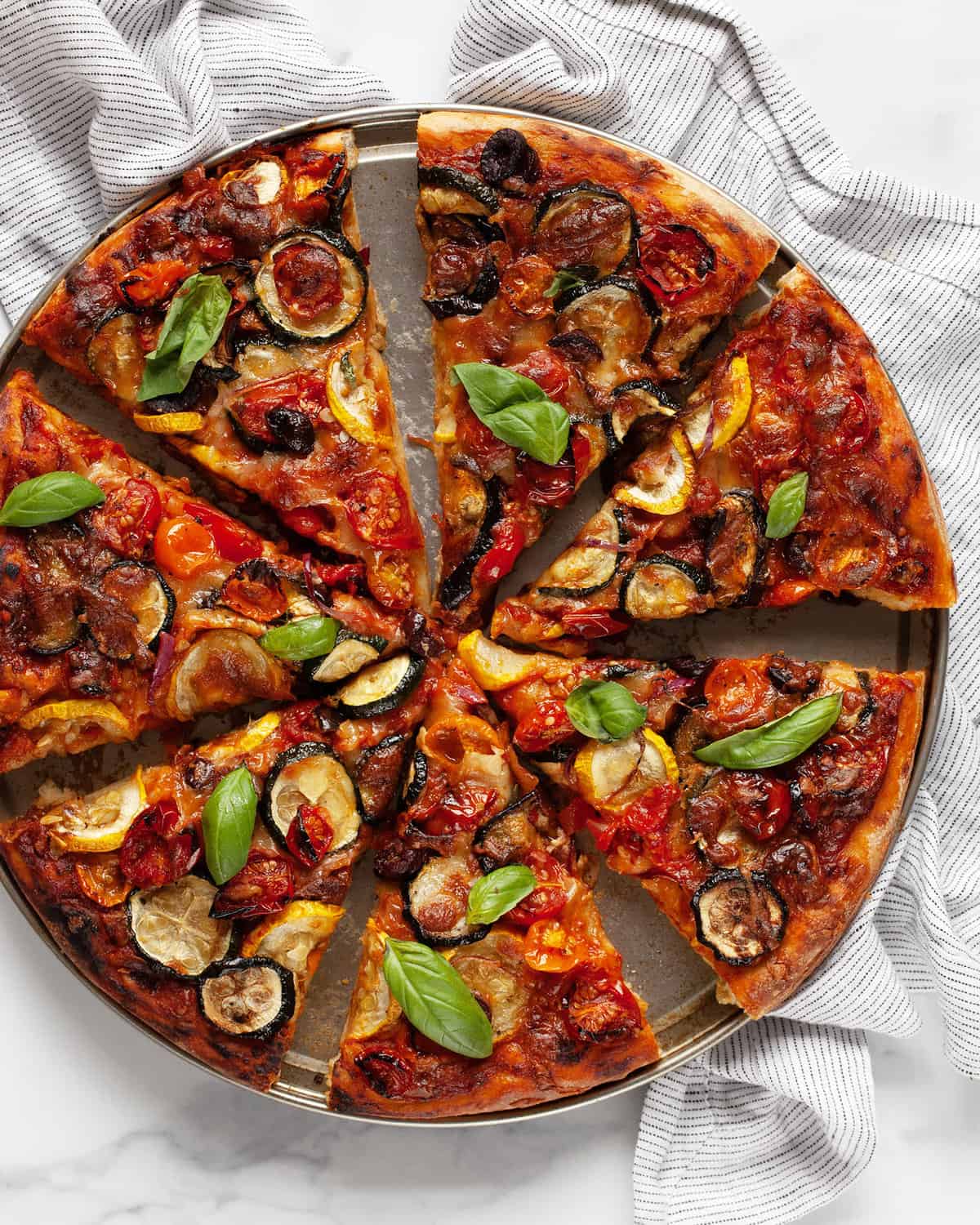 Sliced roasted vegetable pizza.