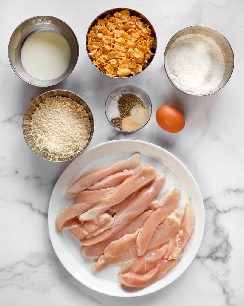Ingredients including chicken, cornflakes, panko breadcrumbs, eggs and spices