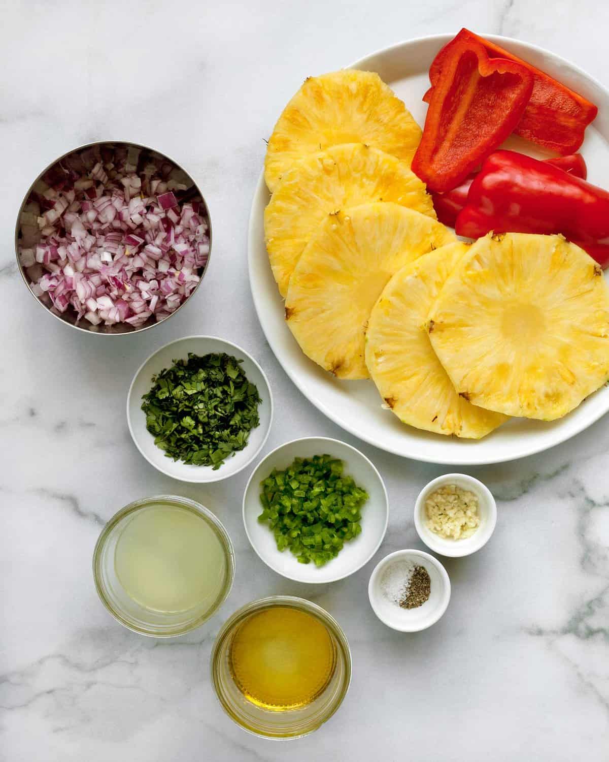 Ingredients including pineapple, red peppers, onions, jalapenos, cilantro, lime juice, garlic, salt & pepper.