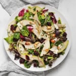 Pear mixed greens salad on a plate.