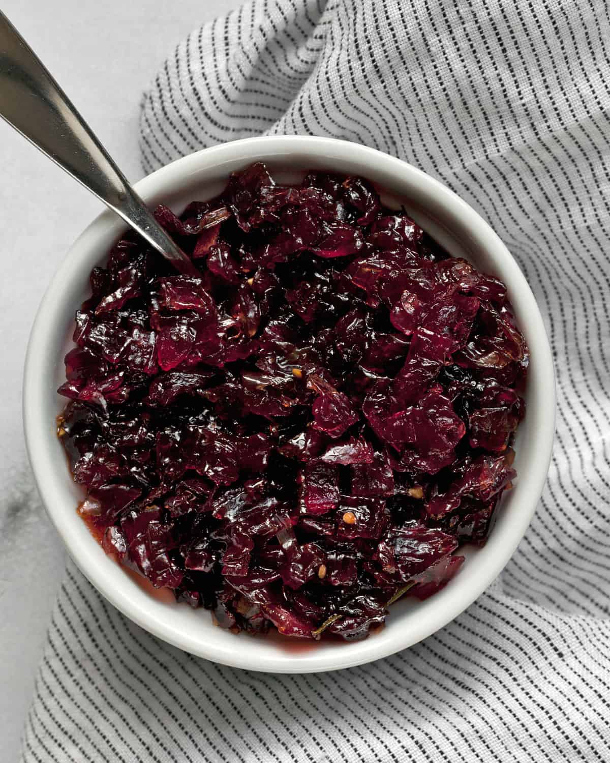 Onion jam in a bowl with a spoon.