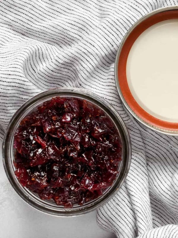 Onion jam in a jar with a lid next to it.