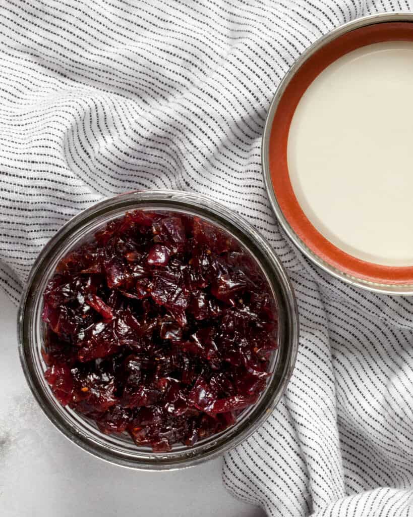 Onion jam in a jar with a lid next to it.