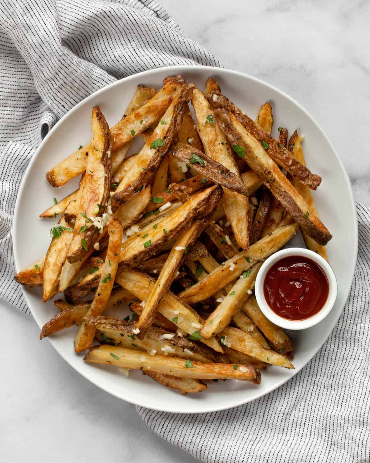 Oven-baked french fries on a plate with ketchup.