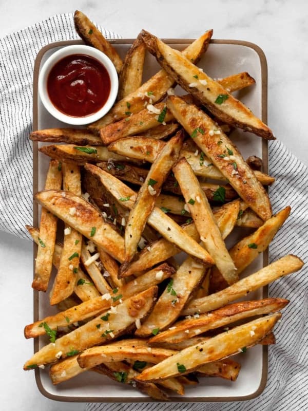 Baked garlic fries with ketchup on a plate.