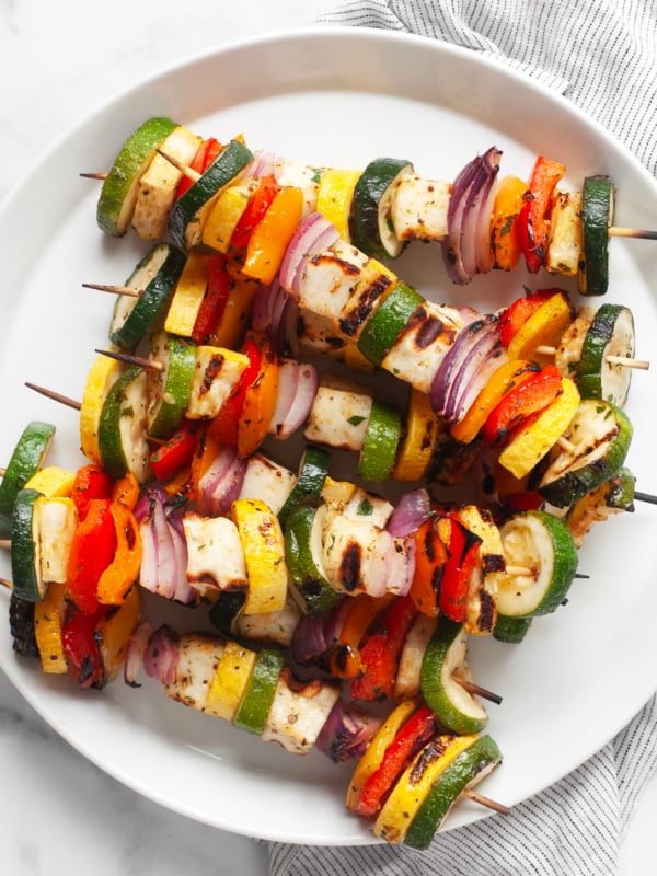Grilled halloumi veggie skewers on a plate.