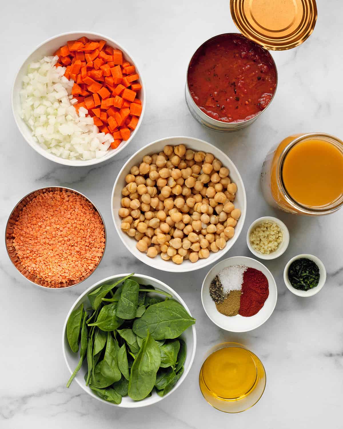 Ingredients including lentils, carrots, spinach, onions, olive oil, garlic and spices.
