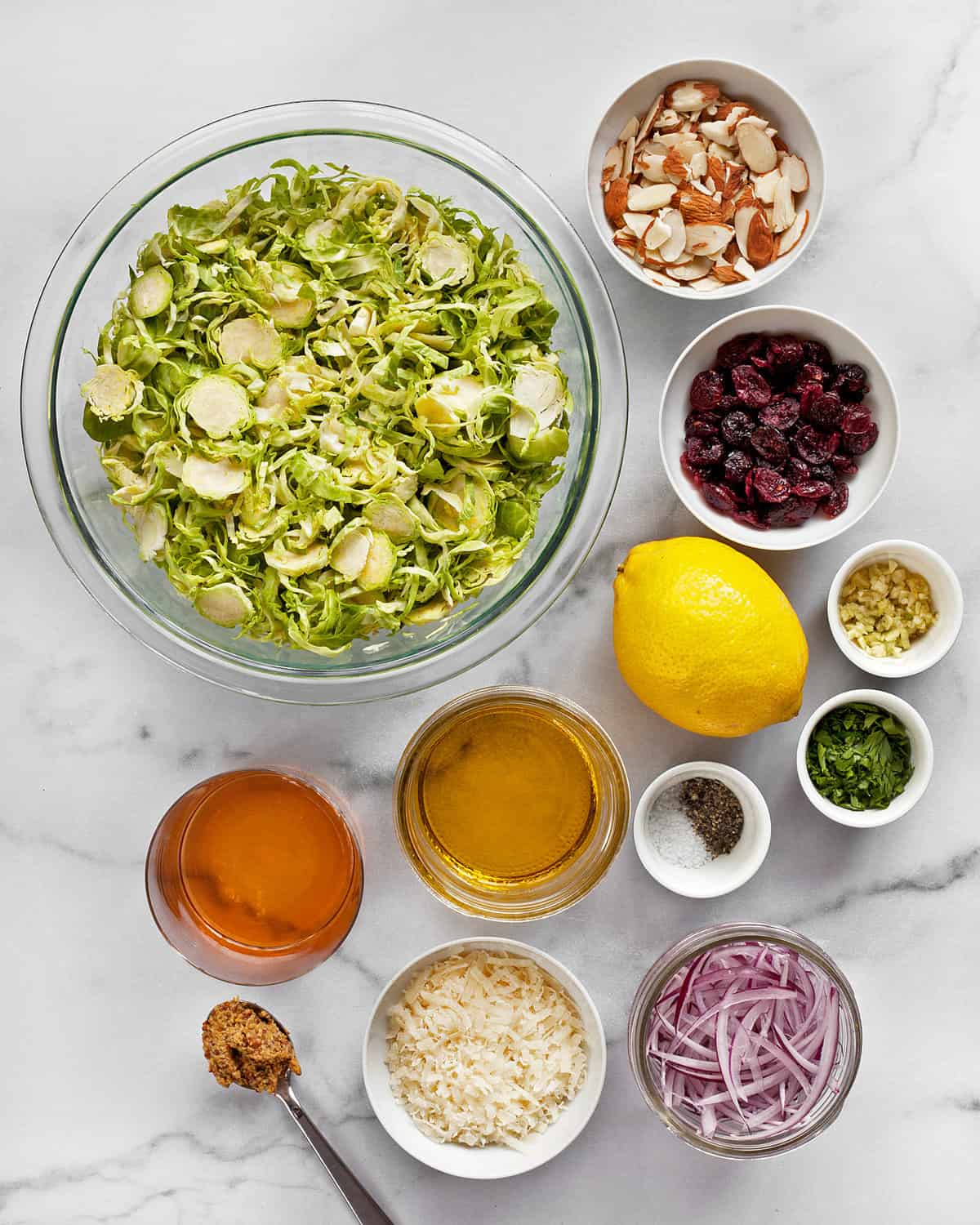 Ingredients including brussels sprouts, cranberries, almonds, Parmesan, lemon, olive oil, vinegar and mustard.