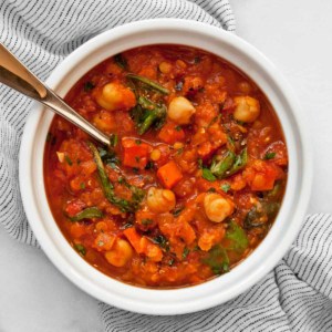 Lentil soup with chickpeas, carrots and spinach in a bowl.