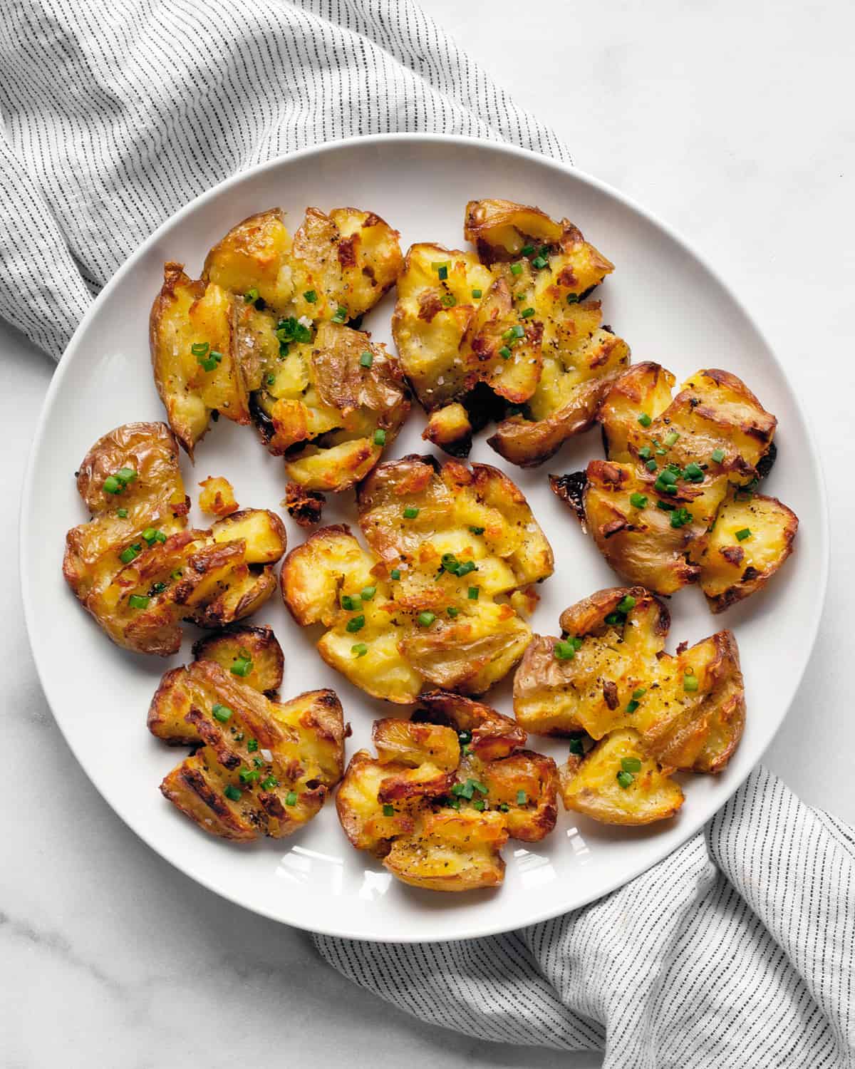 Roasted smashed potatoes on a plate.