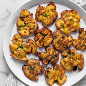 Roasted smashed potatoes on a plate.