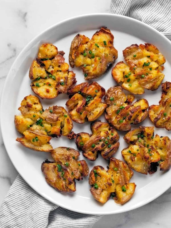 Roasted smashed potatoes on a plate.