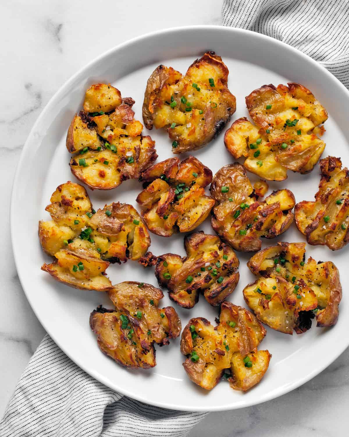 Roasted smashed potatoes on a plate.