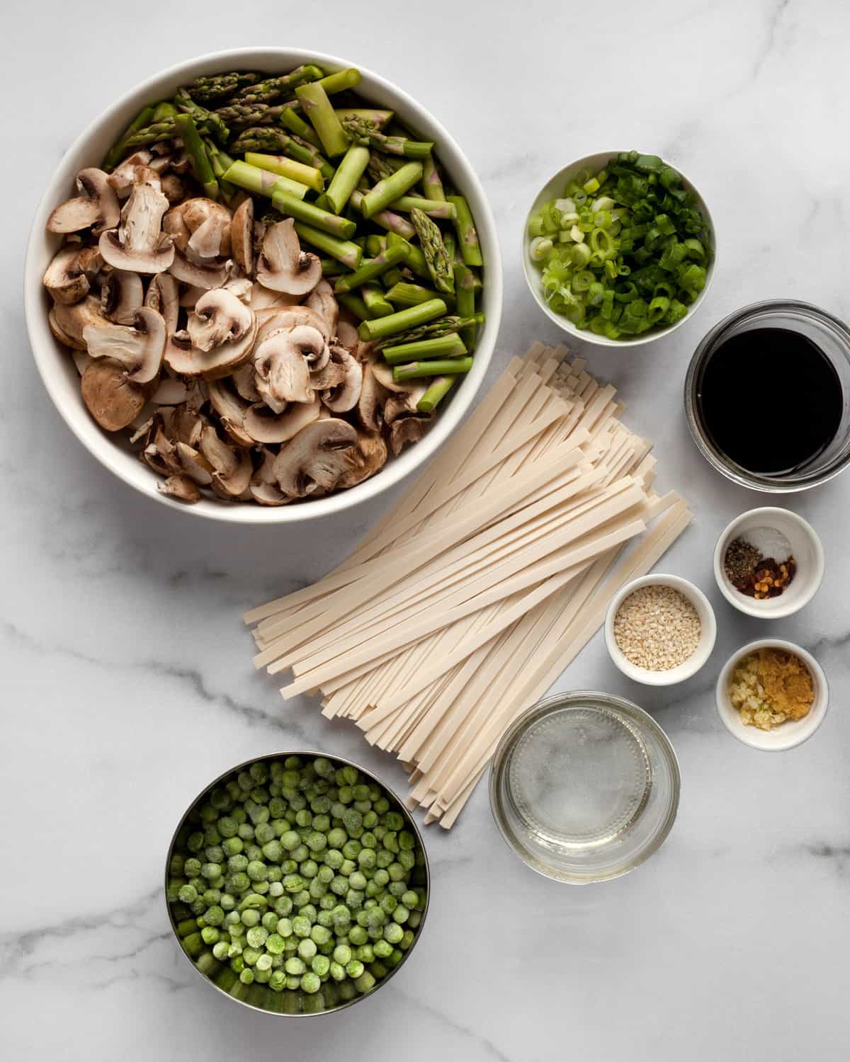 Ingredients including asparagus, mushrooms, peas, scallions, garlic, ginger, soy sauce and udon noodles.