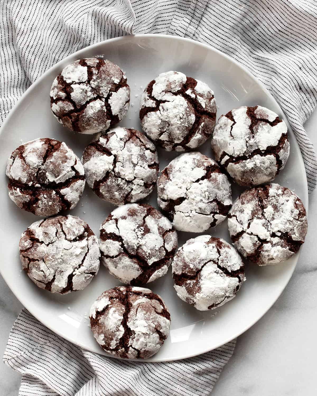 Chocolate crinkle cookies on a serving plate.