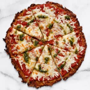 Cauliflower pizza crust cut into 8 slices.