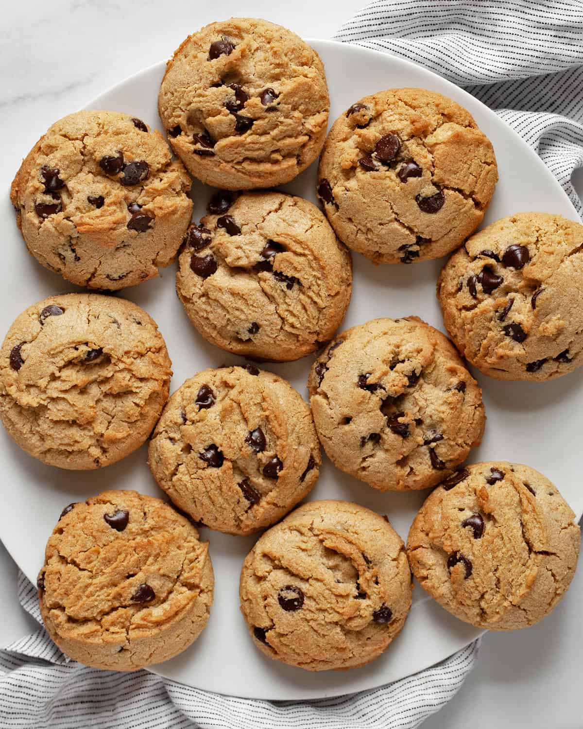 A large plate with peanut butter chocolate chips cookies.