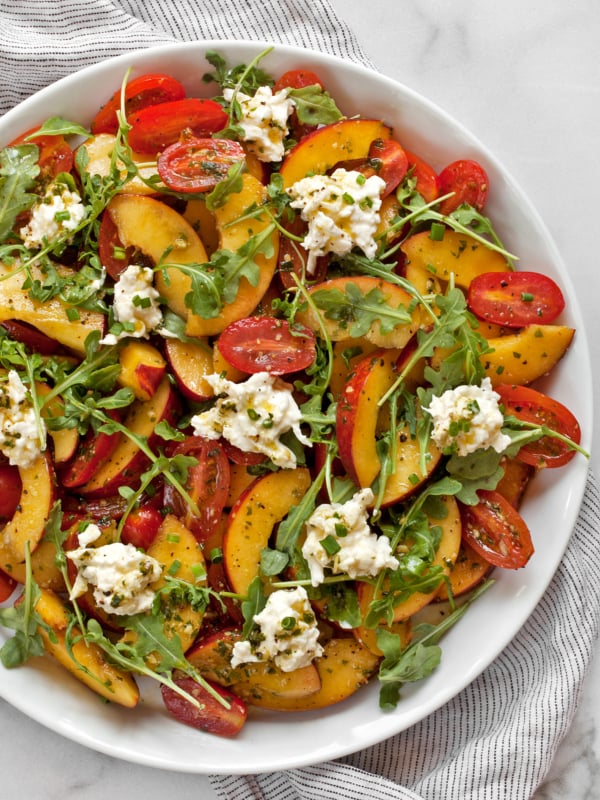 Peach burrata salad with tomatoes on a plate.