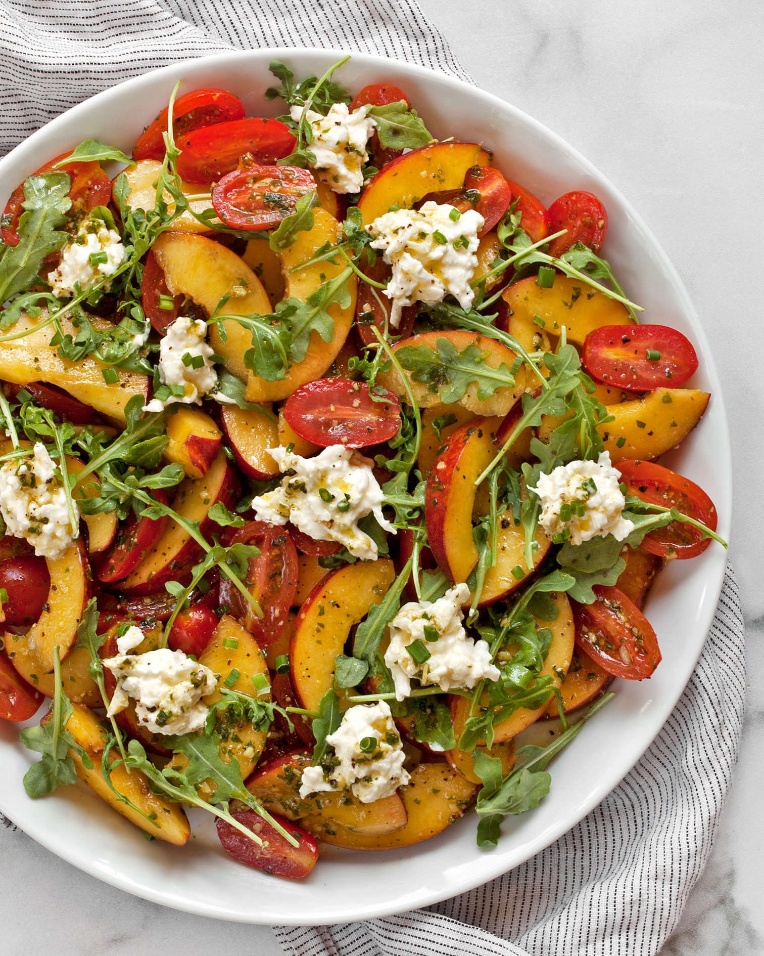 Peach burrata salad with tomatoes on a plate.