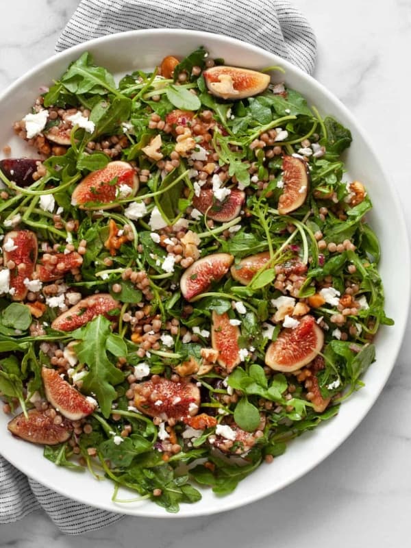 Fresh fig salad with arugula and couscous on a plate.