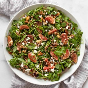 Fresh fig salad with arugula and couscous on a plate.