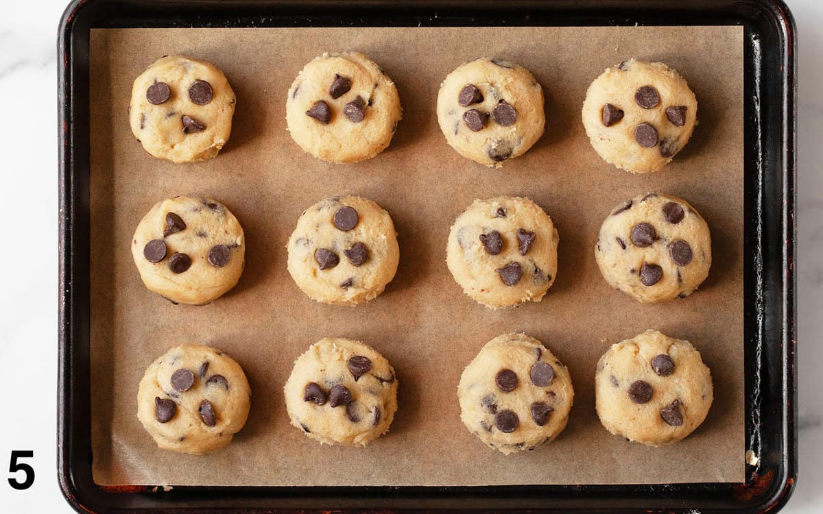 Shaped chocolate chip cookie dough on a pan.