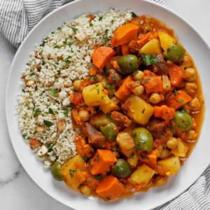 Root vegetable tagine with lemon almond couscous served on a plate