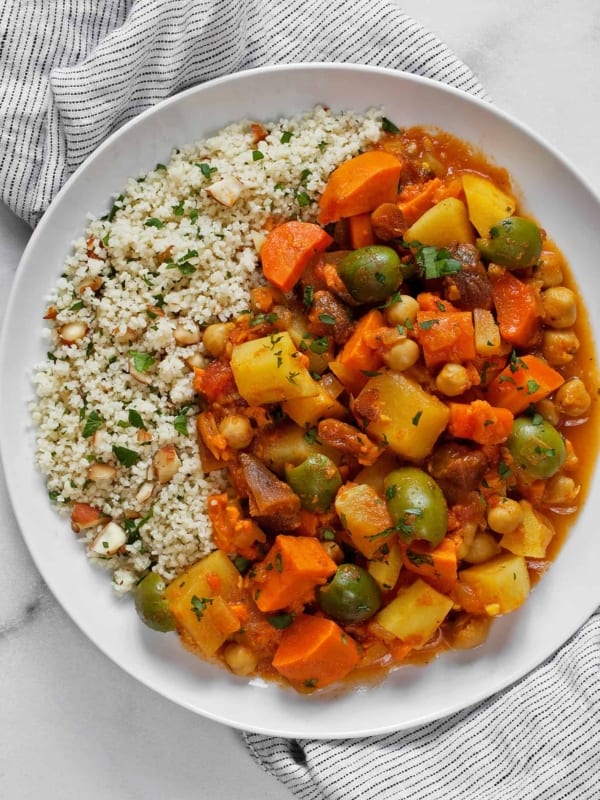 Root vegetable tagine with lemon almond couscous served on a plate