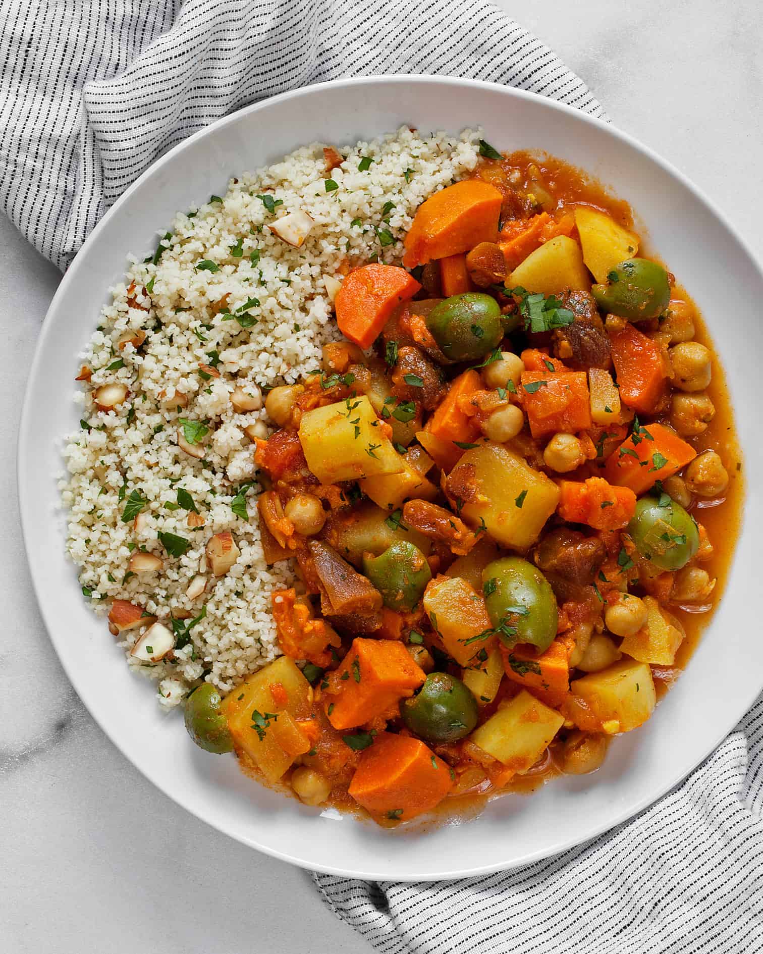 Root vegetable tagine with lemon almond couscous served on a plate