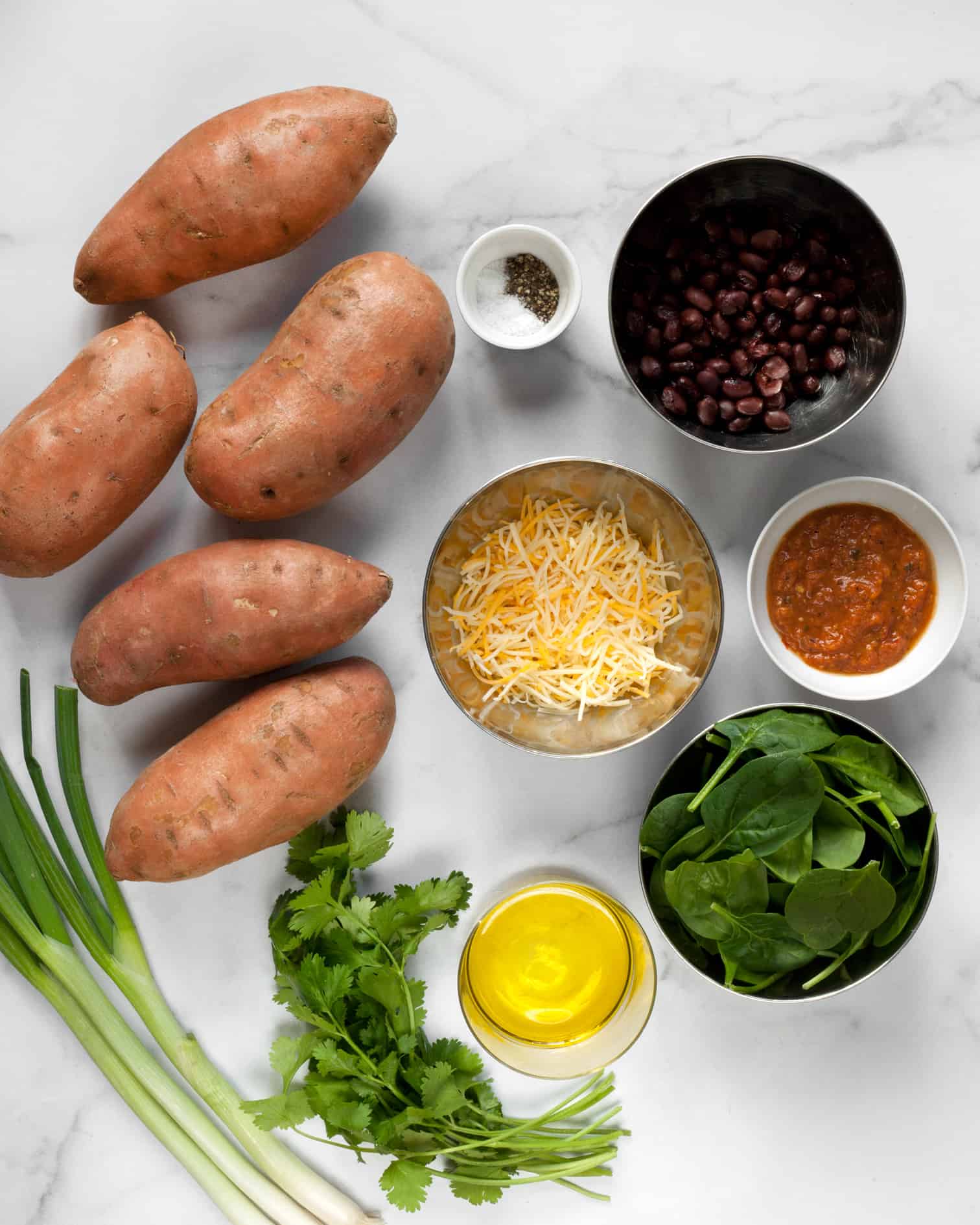 Ingredients including sweet potatoes, black beans, spinach, scallions, cilantro and cheese