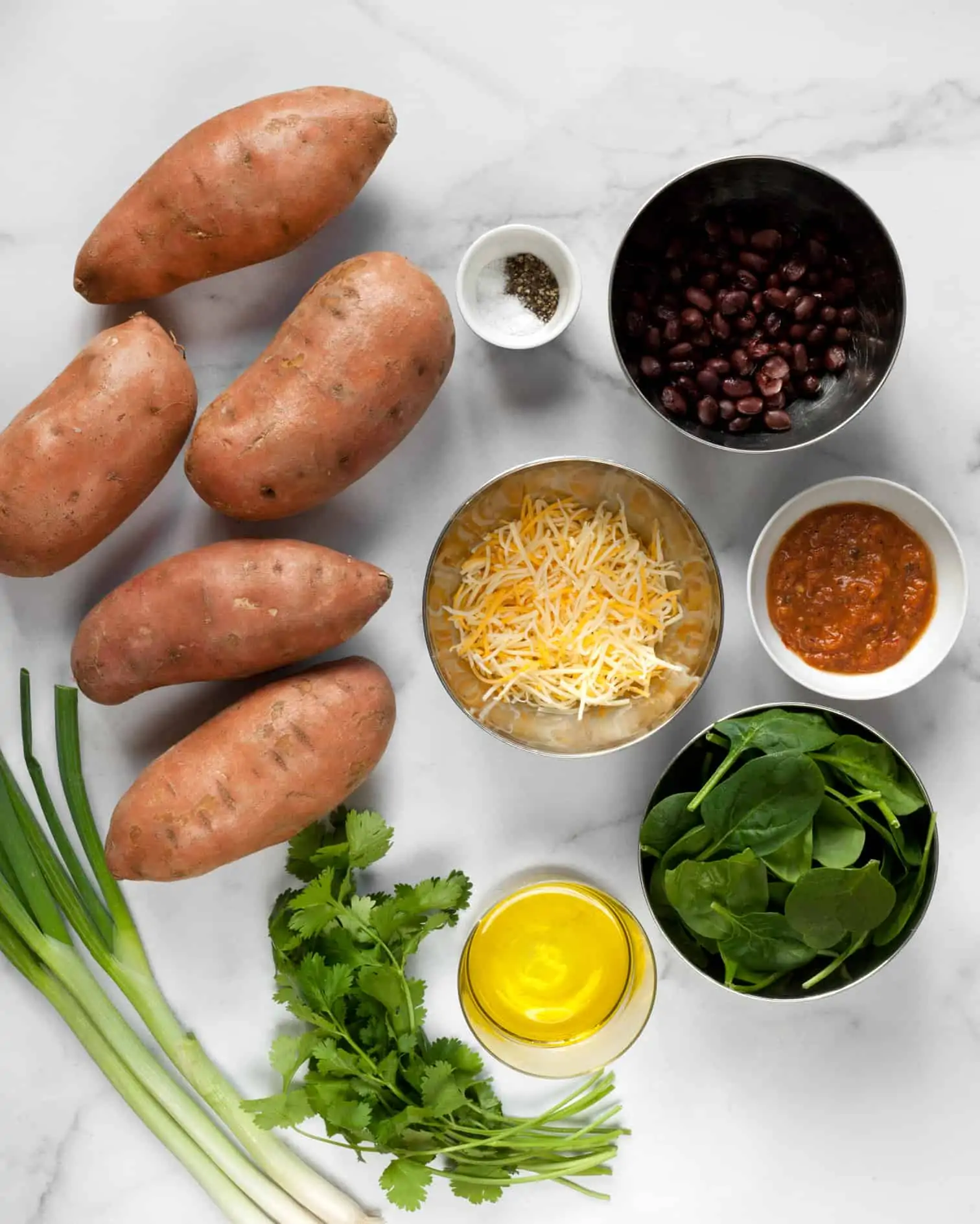 Ingredients including sweet potatoes, black beans, spinach, scallions, cilantro and cheese