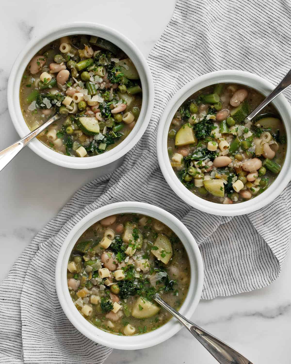 Three bowls of minestrone soup.