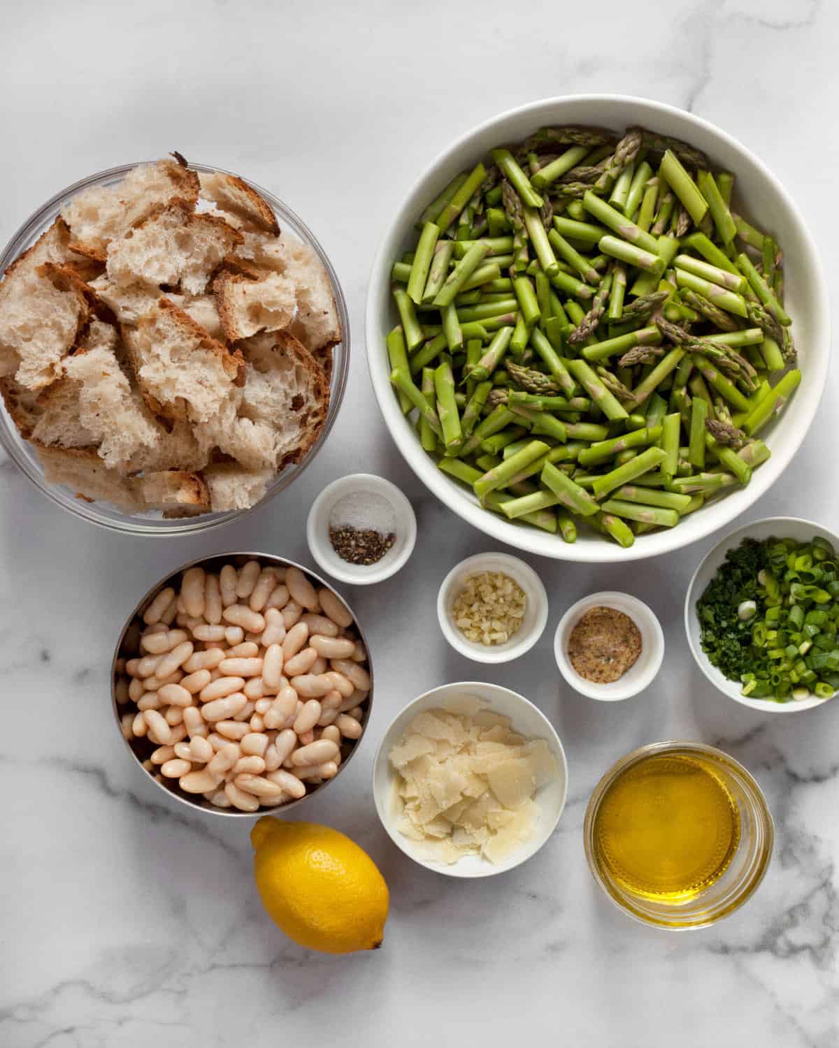 Ingredients including asparagus, bread, white beans, lemon, parmesan, garlic, salt, pepper and olive oil.