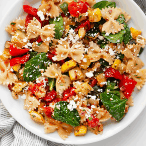 Roasted vegetable bow tie pasta salad on a plate.