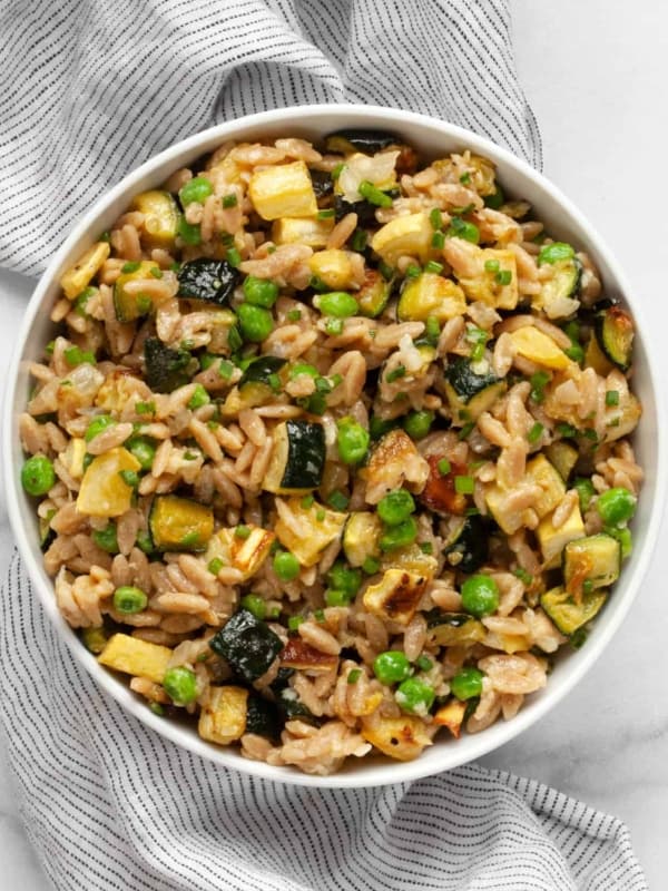 Parmesan orzo with squash and zucchini in bowl.