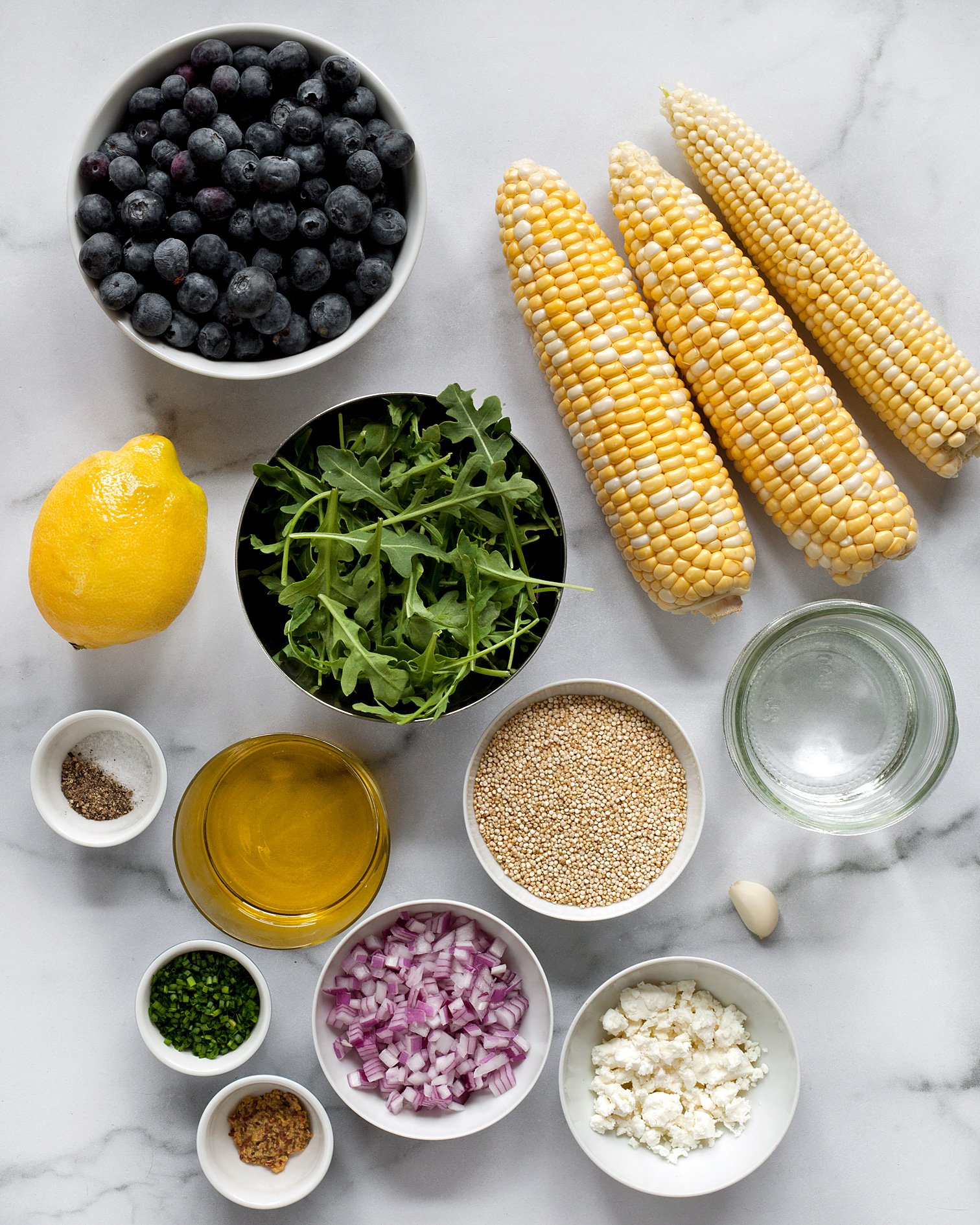 Ingredients including blueberries, corn, arugula, quinoa and feta.