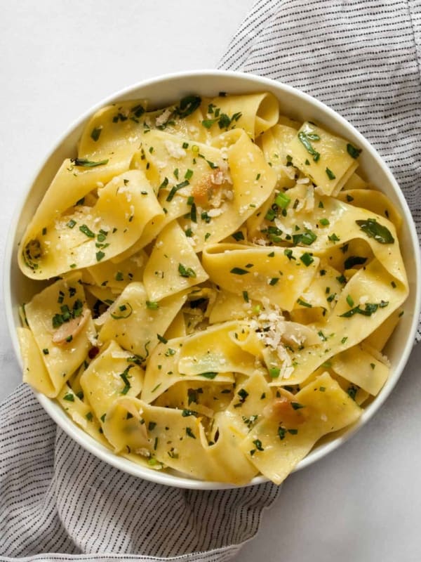 Herb pappardelle pasta in a small bowl.