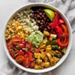 Assembled vegetarian burrito bowl with grilled veggies, black beans and pico de gallo.