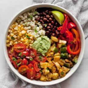 Assembled vegetarian burrito bowl with grilled veggies, black beans and pico de gallo.