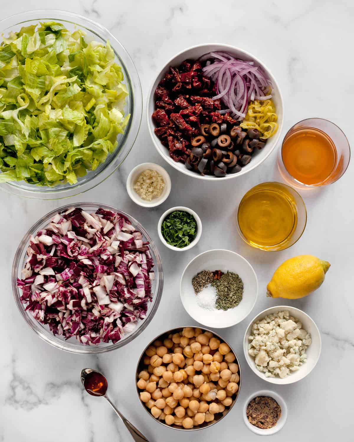 Ingredients including romaine, radicchio, chickpeas, red onions, sun-dried tomatoes, pepperoncini, olives, gorgonzola and parsley