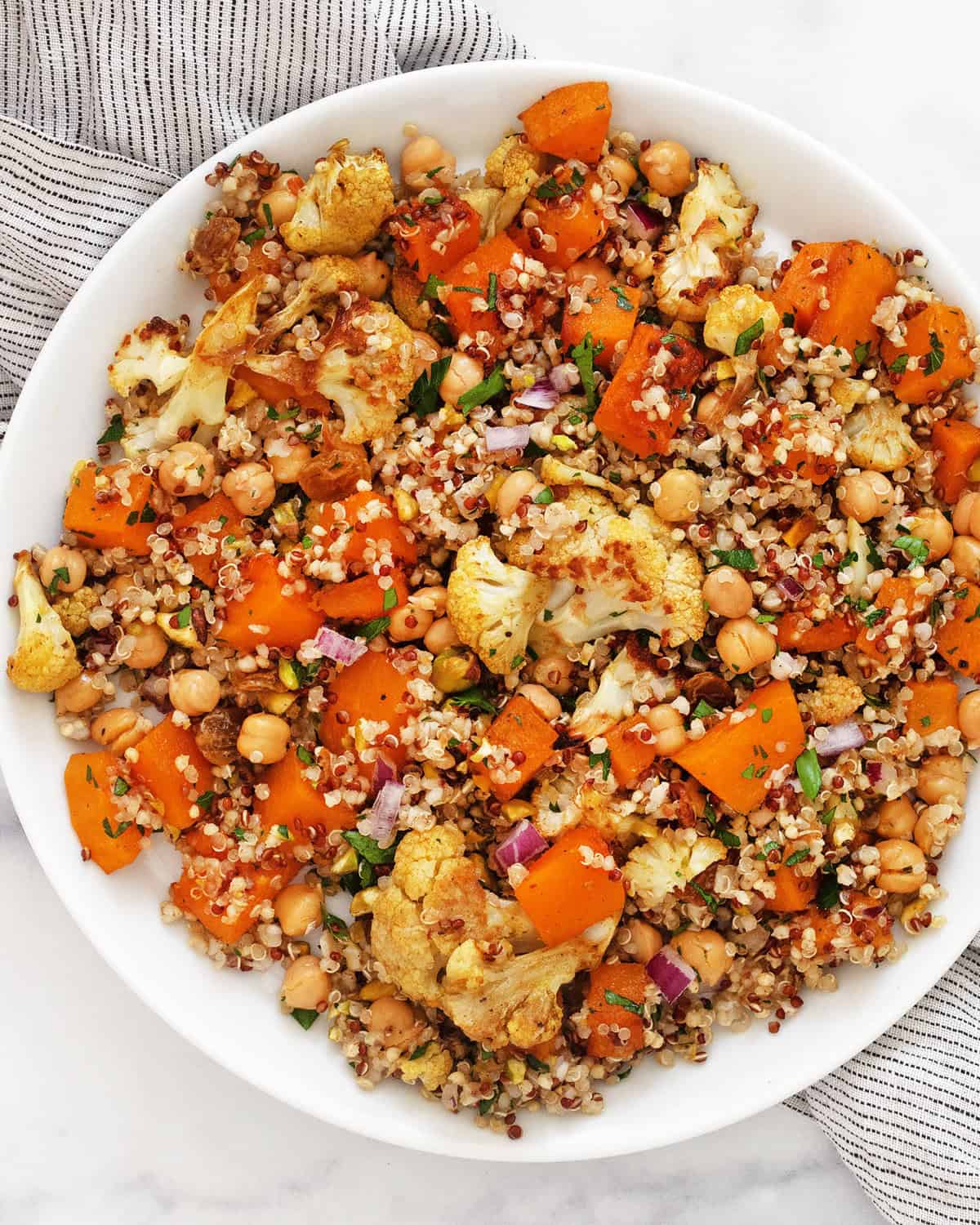 Roasted butternut squash cauliflower quinoa on a plate.