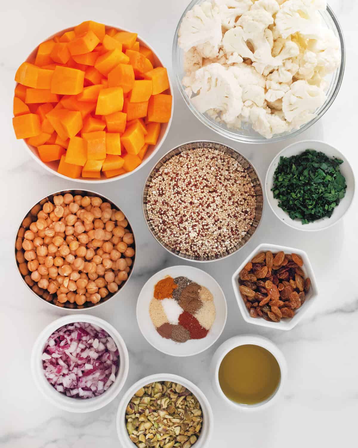 Butternut squash, cauliflower, quinoa, chickpeas, red onions, parsley, raisins, pistachios, olive oil and dried spices.