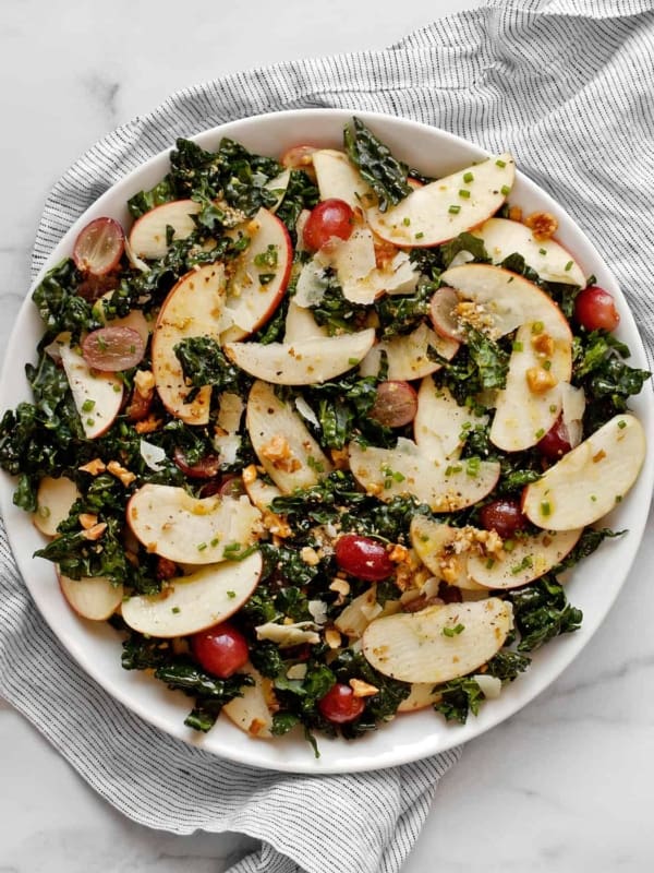 Kale salad with apples, grapes and walnuts on a plate.