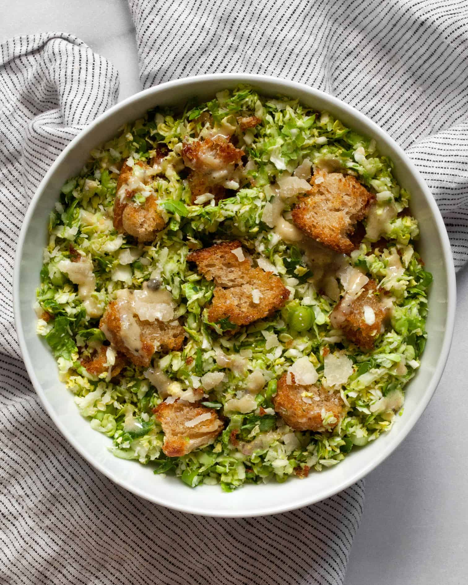 Shredded brussels sprout Caesar salad in a bowl.