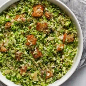 Caesar salad with brussels sprouts in a bowl.