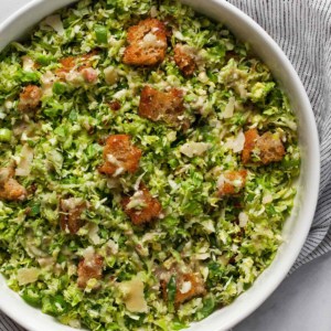 Caesar salad with brussels sprouts in a bowl.