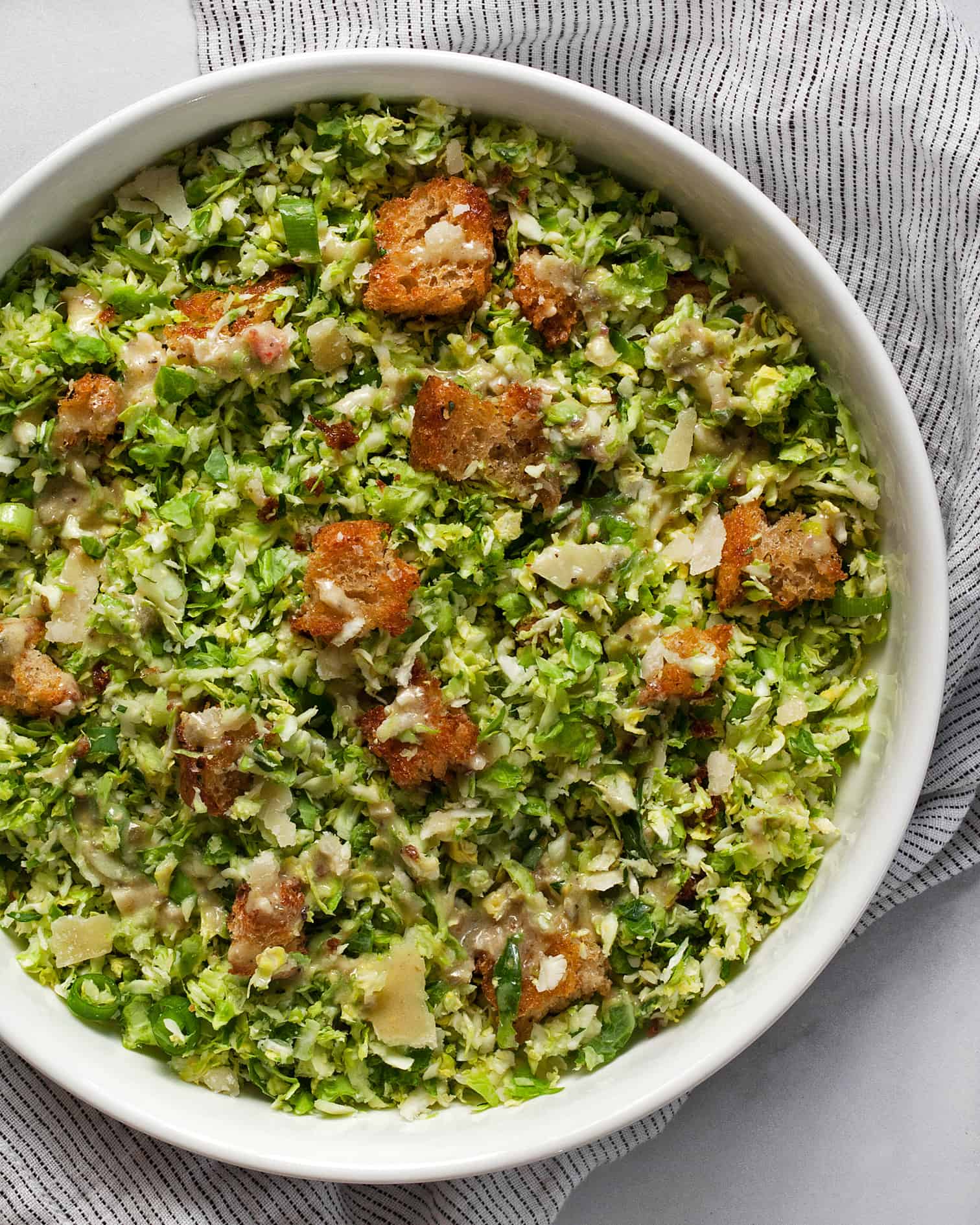 Caesar salad with brussels sprouts in a bowl.